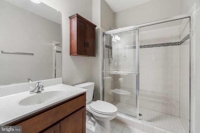 bathroom with tile patterned flooring, vanity, toilet, and walk in shower