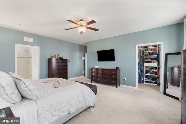 bedroom with a spacious closet, a closet, ceiling fan, and light colored carpet