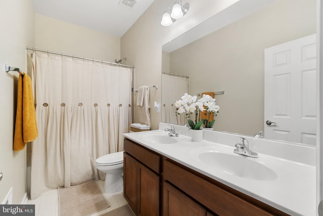 bathroom with tile patterned flooring, vanity, and toilet