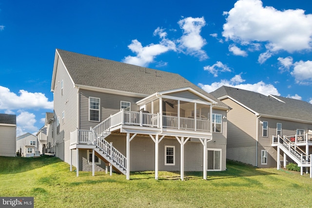 back of house featuring a sunroom, a deck, and a lawn