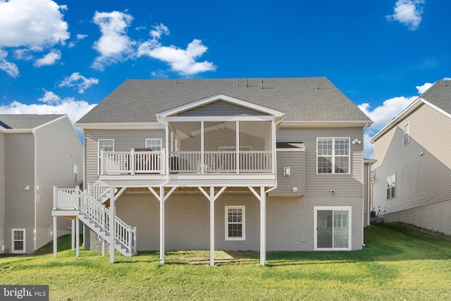 back of property featuring a yard, a deck, and a sunroom