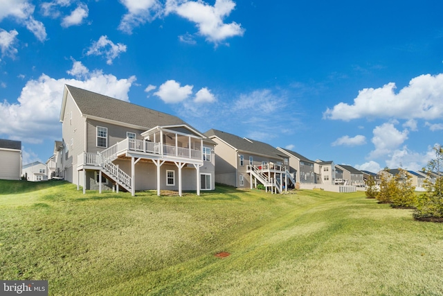 back of property featuring a lawn, a sunroom, and a deck