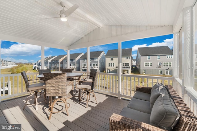 sunroom / solarium featuring ceiling fan, lofted ceiling with beams, and a wealth of natural light