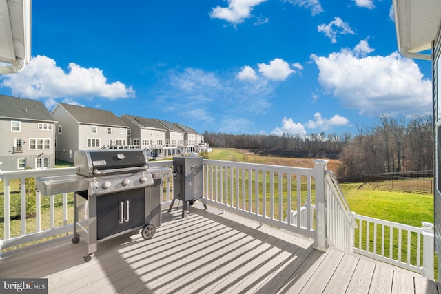 wooden terrace featuring grilling area and a yard