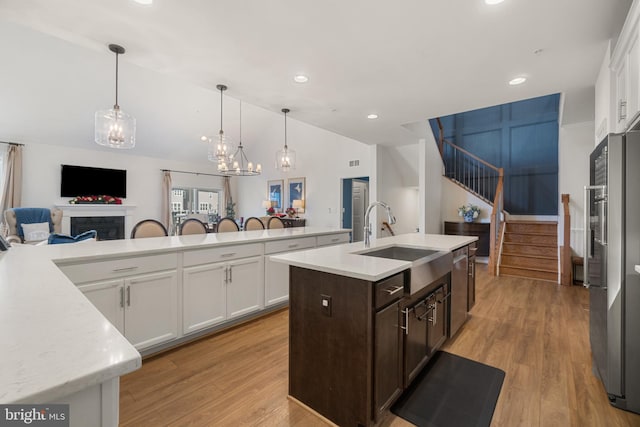 kitchen with white cabinetry, a center island with sink, sink, and appliances with stainless steel finishes