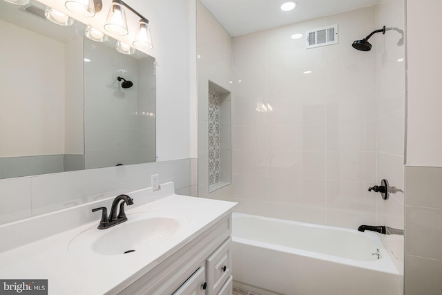 bathroom with vanity and tiled shower / bath