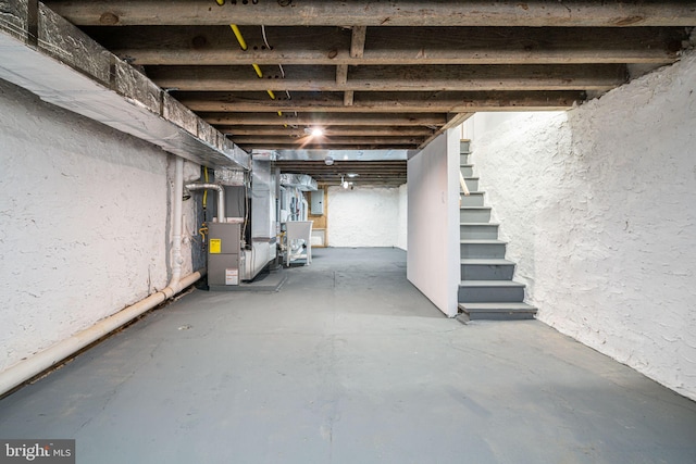 basement featuring electric panel and heating unit