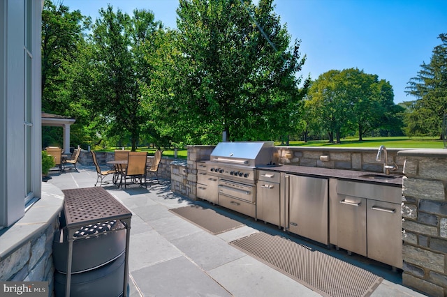 view of patio featuring area for grilling and sink