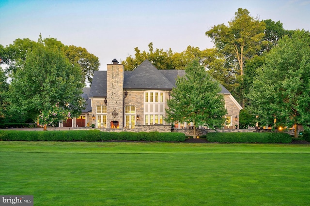 rear view of property featuring a lawn