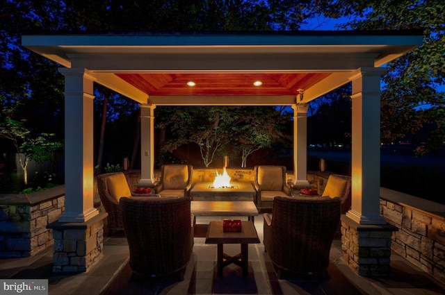 patio at twilight with a gazebo and an outdoor living space with a fire pit