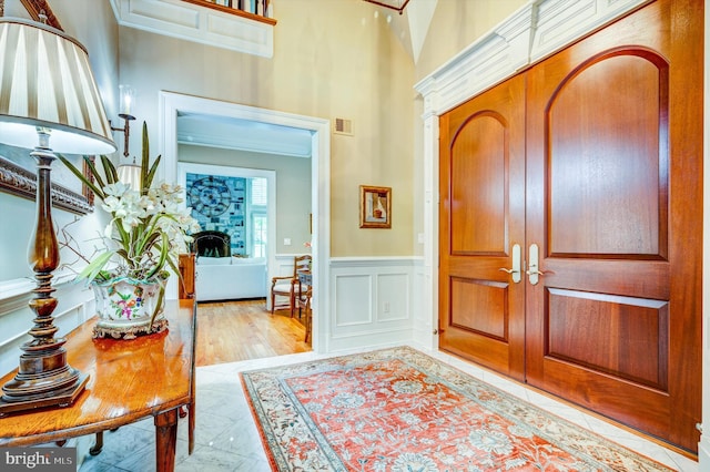 foyer featuring light hardwood / wood-style floors and crown molding