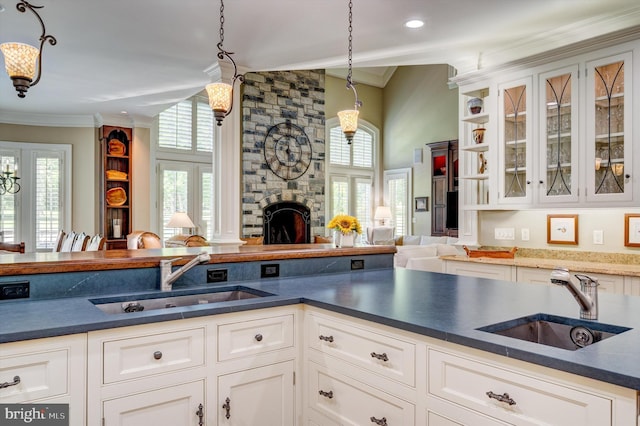 kitchen with white cabinetry, sink, and hanging light fixtures