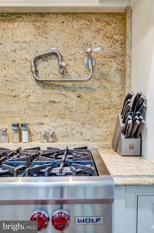 interior details featuring gas stove and crown molding