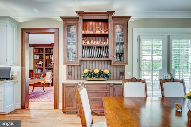 bar with light hardwood / wood-style floors and ornamental molding