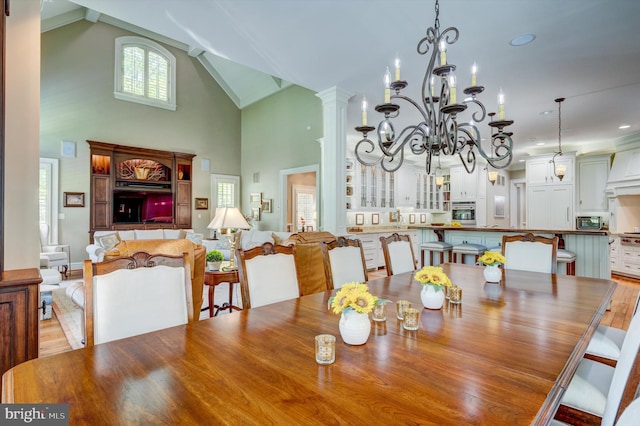 dining room with an inviting chandelier, light hardwood / wood-style floors, and high vaulted ceiling