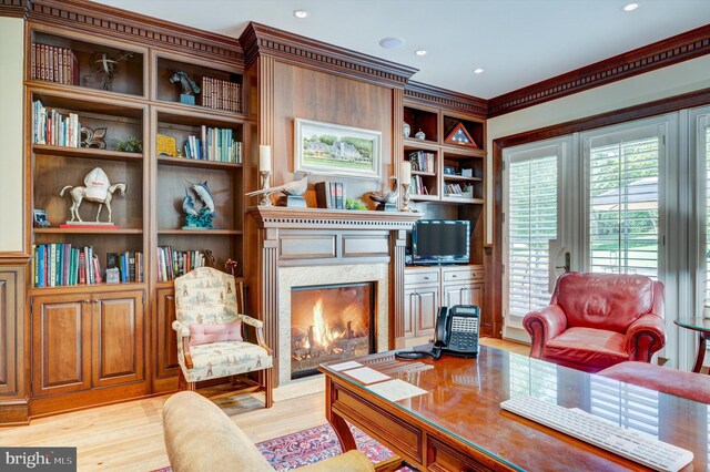 office area with crown molding, a premium fireplace, and light wood-type flooring