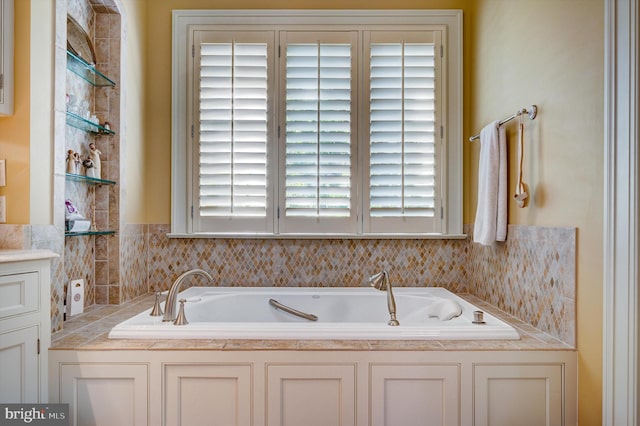 bathroom with a bath, vanity, and plenty of natural light