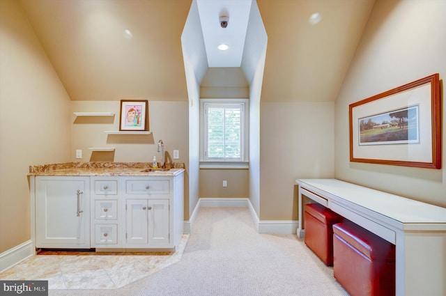 bathroom featuring vanity and lofted ceiling