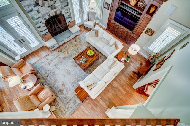 living room with hardwood / wood-style flooring, a fireplace, and a high ceiling