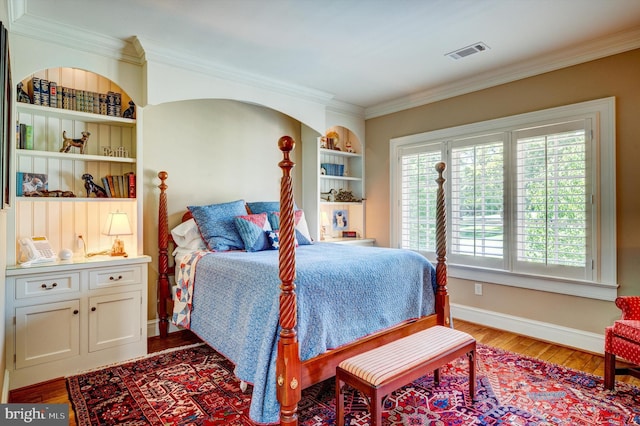 bedroom with wood-type flooring and ornamental molding