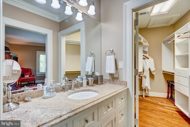 bathroom featuring vanity, ornamental molding, and hardwood / wood-style flooring