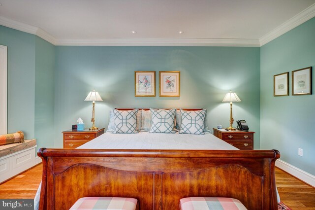 bedroom featuring light wood-type flooring and crown molding