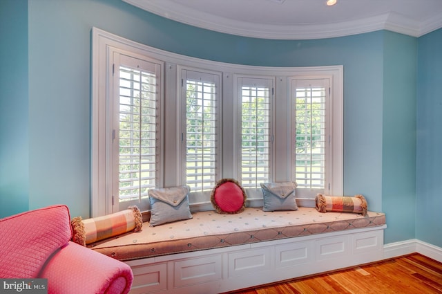 living area with ornamental molding, a wealth of natural light, and light hardwood / wood-style flooring