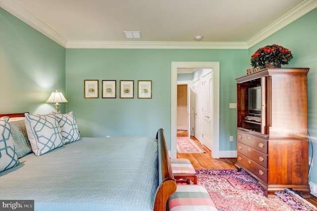 bedroom with light hardwood / wood-style flooring and ornamental molding