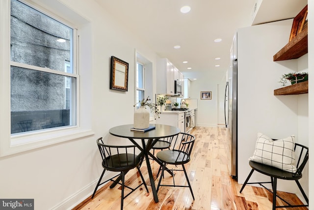 dining space with light hardwood / wood-style floors and a wealth of natural light