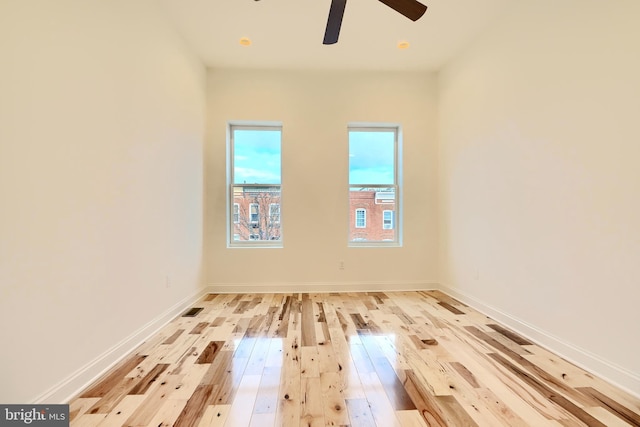 empty room with ceiling fan and light hardwood / wood-style floors