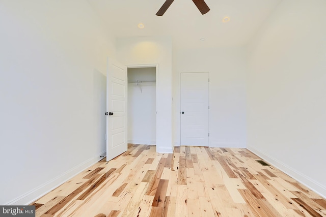 unfurnished bedroom featuring ceiling fan, light wood-type flooring, and a closet