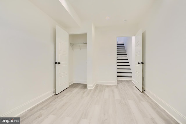 unfurnished bedroom with light hardwood / wood-style floors and a closet