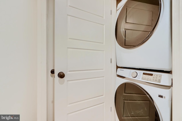 clothes washing area with stacked washer / dryer