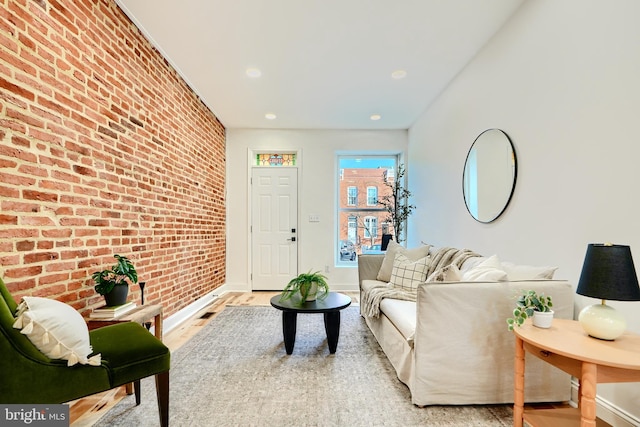 living room featuring light hardwood / wood-style flooring and brick wall