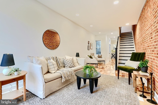 living room featuring light hardwood / wood-style floors and brick wall