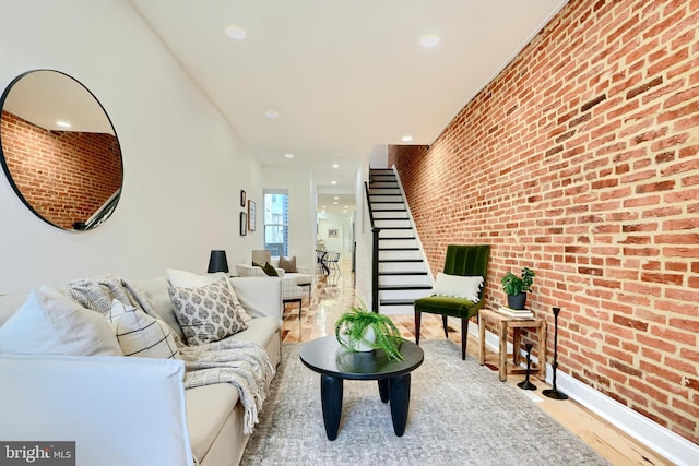 living room with brick wall and light wood-type flooring