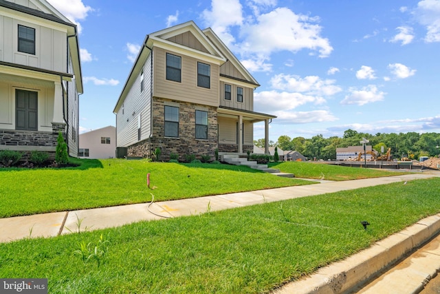 craftsman-style home featuring covered porch, central AC unit, and a front lawn