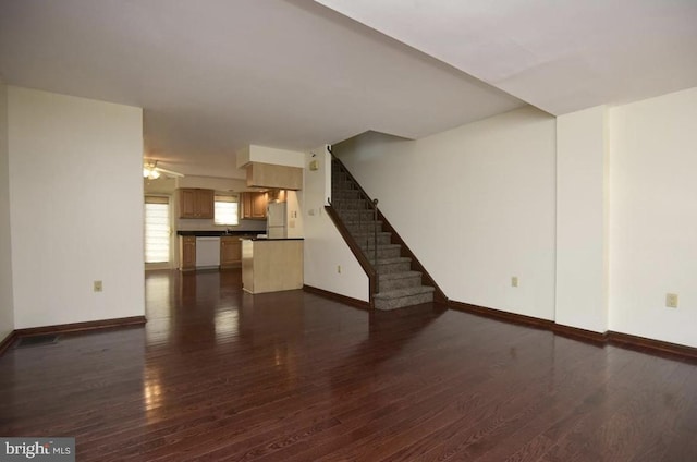 unfurnished living room featuring ceiling fan and dark hardwood / wood-style floors