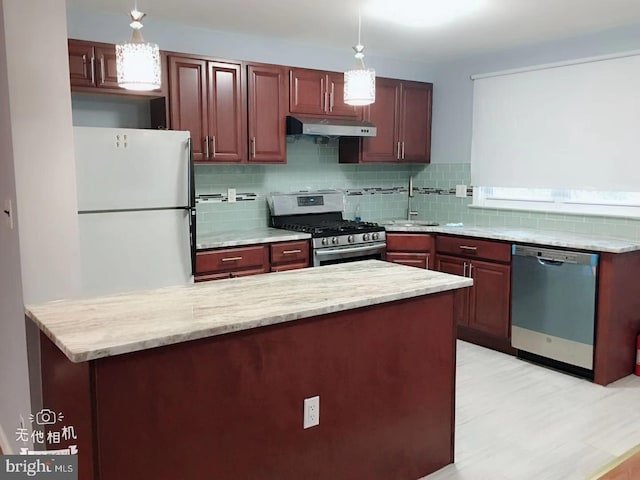 kitchen with decorative backsplash, pendant lighting, stainless steel appliances, and sink