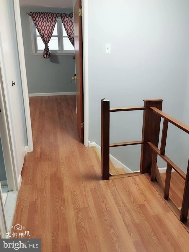 hallway with light hardwood / wood-style floors