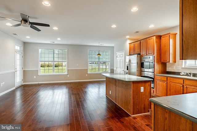 kitchen with decorative light fixtures, tasteful backsplash, dark hardwood / wood-style flooring, a center island, and stainless steel appliances