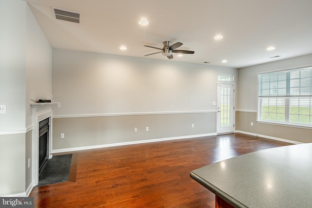 unfurnished living room with dark hardwood / wood-style floors and ceiling fan