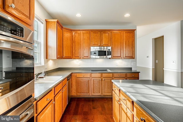 kitchen featuring stainless steel appliances, dark hardwood / wood-style floors, sink, and backsplash