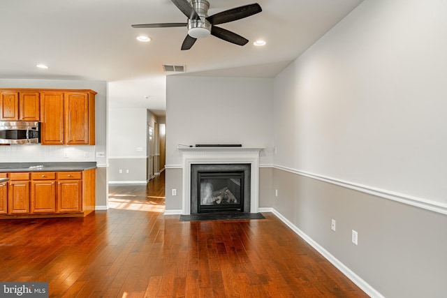 unfurnished living room featuring dark hardwood / wood-style floors and ceiling fan