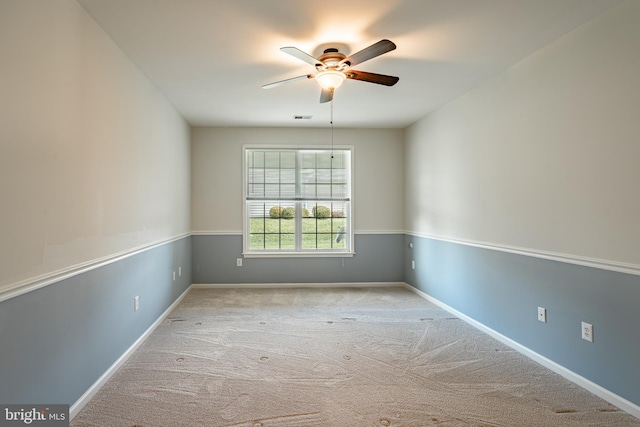 spare room featuring light carpet and ceiling fan