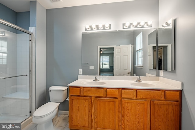 bathroom with vanity, a shower with door, tile patterned floors, and toilet