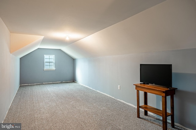 additional living space with vaulted ceiling and carpet flooring