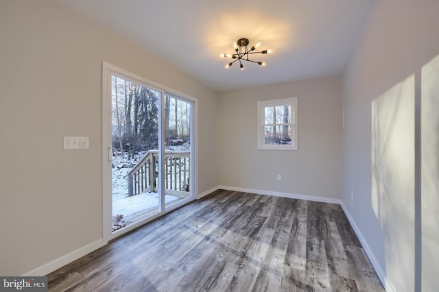 unfurnished dining area featuring a chandelier and hardwood / wood-style floors