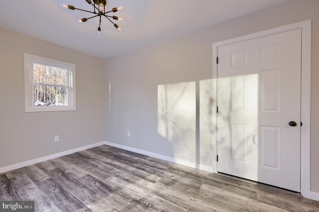 unfurnished bedroom featuring light hardwood / wood-style flooring and a notable chandelier