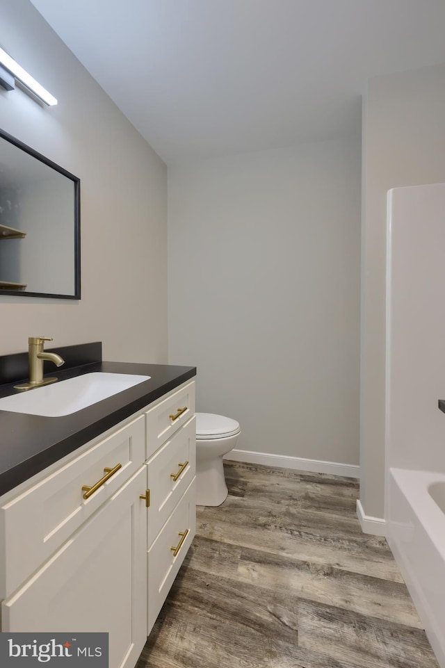 bathroom featuring vanity, hardwood / wood-style flooring, and toilet